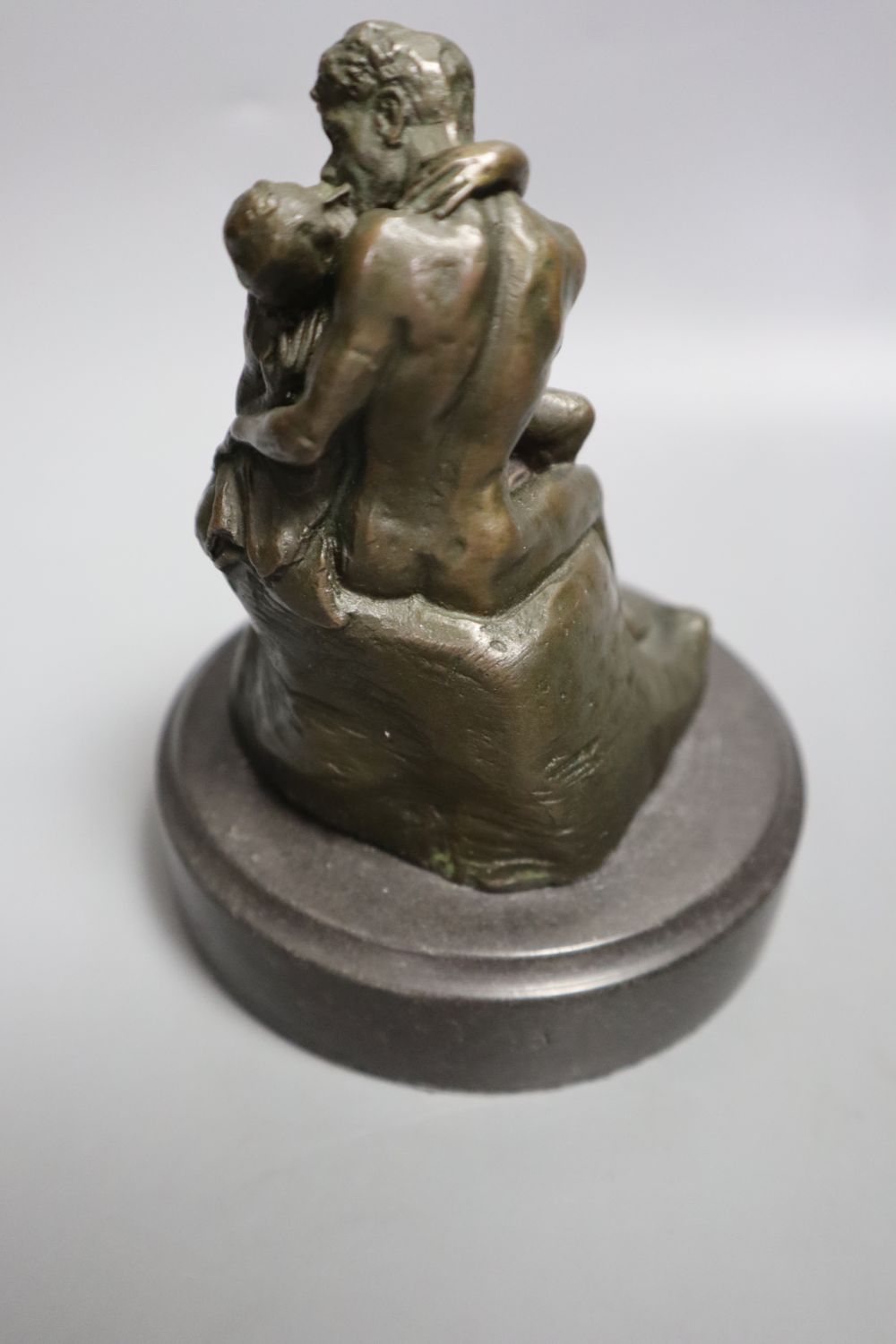 A cast metal sculpture Kiss after Rodin, height 14cm and another of Arabs